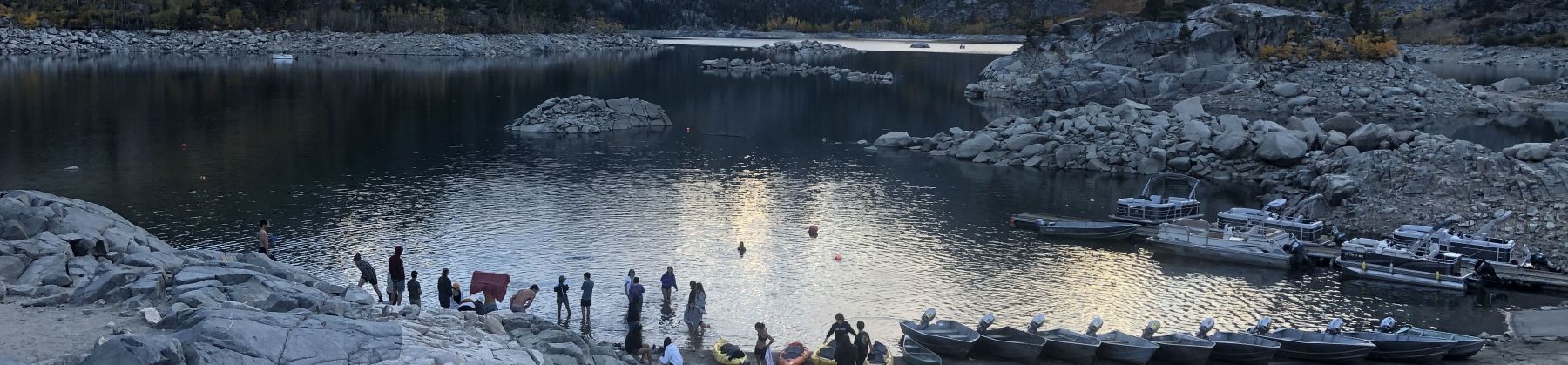 Lake in a mountain valley with peopel gathering on the waterfront