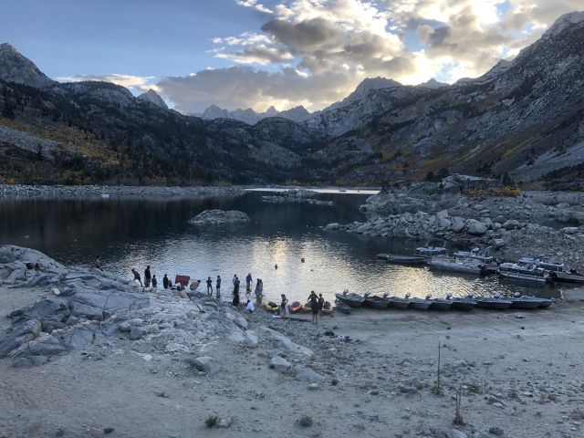 Lake in a mountain valley with peopel gathering on the waterfront
